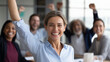 © Nataliya - Group of happy coworkers cheering together in a conference room, team celebration and success concept, defocused background, with copy space