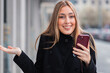 © carballo - young woman with phone and questioning expression