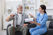 © New Africa - Care worker with clipboard talking to senior man indoors