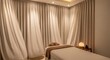 © mochalfin - Spa treatment room interior with massage table and curtains open