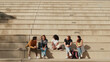 © Andrii Nekrasov - Friends Studying Together On Concrete Bleacher Steps