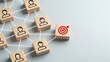 © Charlotte - Wooden cubes with human icons connected by white lines to a red target symbol on a gray background representing networking teamwork business strategy and goal achievement concepts