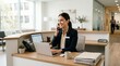 © Fiverr/fazilazia703 - Smiling professional businesswoman at a modern office reception, multi-tasking with a phone call and laptop work.