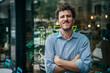© TrueShot | Westend61 - Happy businessman with arms crossed standing outside cafe