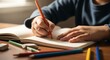 © Rosyid - Child's Hands Drawing or Writing in Notebook with Colored Pencil on Wooden Desk