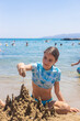 © yanadjan - Children playing with sand on the beach. Selective focus.