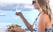 © yanadjan - Greek salad and wine in Greece in a restaurant woman. Selective focus.