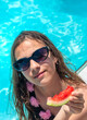 © yanadjan - girl eating watermelon near the pool. selective focus.