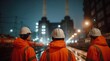 © Studio Zenith - Trois ouvriers en gilets orange observent un chantier industriel nocturne