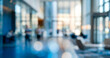 © Vhagar - Softly blurred modern office interior filled with natural light, featuring glass walls, tall columns, and indistinct figures moving through a spacious corporate lobby atmosphere.