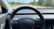 © ArtStockVault - Steering Wheel POV Driving on Highway with Green Landscape and Blue Sky