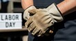 © SALMA1234 - A person wearing work gloves standing next to a labor day sign, symbolizing workers and labor
