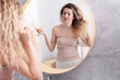© New Africa - Unhappy woman with tangled hair near mirror in bathroom