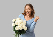 © Pixel-Shot - Beautiful happy young woman with bouquet of white roses on grey background