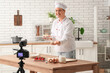 © Pixel-Shot - Male chef with muffins recording cooking video in kitchen