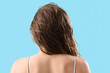 © Pixel-Shot - Young woman after washing hair on blue background, back view