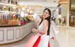 © dodotone - Portrait enjoy young adult asian woman holding shopping bags at indoor department store fashion and beauty consumerism lifestyle