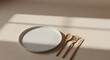 © Eunseom - Golden cutlery set beside an empty plate on a table indoors.