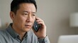 © gn8 - Chinese middle aged man reacting to suspicious vishing phone call