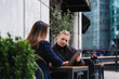 © Westend61 - Colleagues discussing business using a tablet outdoors in urban setting