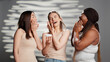 © DC Studio - Group of flawless ladies applying moisturizing face cream in studio, promoting luminous skincare products. Interracial young women using moisturizer and serum for new dermatology campaign.