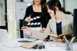 © Nuttapong punna - Creative team planning video production in modern office, using clapperboard, laptop and notebook. Business, marketing, content creation