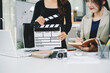 © Nuttapong punna - Creative team planning video production in modern office, using clapperboard, laptop and notebook. Business, marketing, content creation