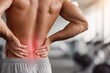 © whitestorm - Man experiencing lower back pain with red highlighted area, holding his aching back in a gym.