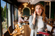 © djile - Woman talking on phone holding tablet in restaurant