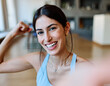 © Lumos sp - Portrait of a fit blatina girl young woman exercising practicing yoga or fitness taking a selfie with mobile phone camera and showing muscle at home