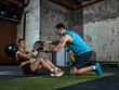 © master1305 - Personal trainer assisting woman with medicine ball during core workout session. Concept of fitness coaching, exercise technique correction and guided strength training