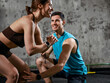 © master1305 - Woman performing squat while man assists with form during gym training session. Concept of personal coaching, strength development, fitness program support and safe exercise technique