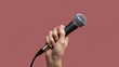 © olga_demina - A close-up shot of a hand holding a microphone, set against a solid muted red background. The conveys a sense of readiness for a radio broadcast or podcast recording, highlighting the importance of