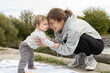 © Anna - young mother joyfully plays with her baby, having fun and admiring the little one. Happy Mother's Day. Tender maternal feelings. The joy of motherhood, tenderness, care. outdoors