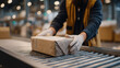 © forenna - Opened returns box on conveyor belt revealing damaged product wrapped in loose bubble wrap, gloved quality inspector examining item, overlit processing facility background, perfect for reverse logis