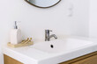 © brizmaker - White bathroom sink with bamboo toothbrushes and soap dispenser