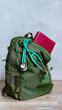 © Sergey - Green backpack with stethoscope and red book on wooden floor