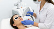 © Максим Новосветлов - Woman wearing protective eyewear receiving professional laser facial treatment for skin rejuvenation and pigmentation at aesthetic clinic.
