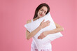 © New Africa - Beautiful woman with pillow on pink background