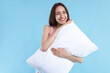 © New Africa - Beautiful woman with pillow on light blue background. Space for text