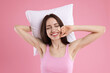 © New Africa - Beautiful woman with pillow on pink background