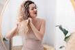 © New Africa - Unhappy woman trying to brush her tangled hair near mirror in bathroom