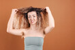 © New Africa - Unhappy woman with tangled hair on brown background