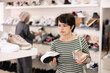 © JackF - Adult female shopper purchases sneakers in shoe store