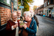 © Davor - Senior friends reading map on historic cobblestone street