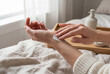 © Desyta - Woman applying hand cream for skin care in bed