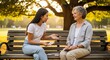 © kinomaster - Friendly senior woman and young adult woman sitting on a park bench at sunset and reviewing colorful memory cards together. Ongoing education. Generative AI.