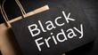 © Anoo - A black paper banner has space for text alongside a black bag featuring Black Friday in white letters. This setup is ideal for a sale promotion