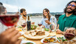 © Davide Angelini - Happy friends having barbecue dinner party at home balcony  - Young people enjoying lunch break at restaurant terrace