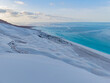 © AmazingAerialAgency - Aerial view of pure white sand dunes meet the turquoise sea under a pastel sky, creating a surreal coastal landscape, Erissel, Socotra, Yemen.
